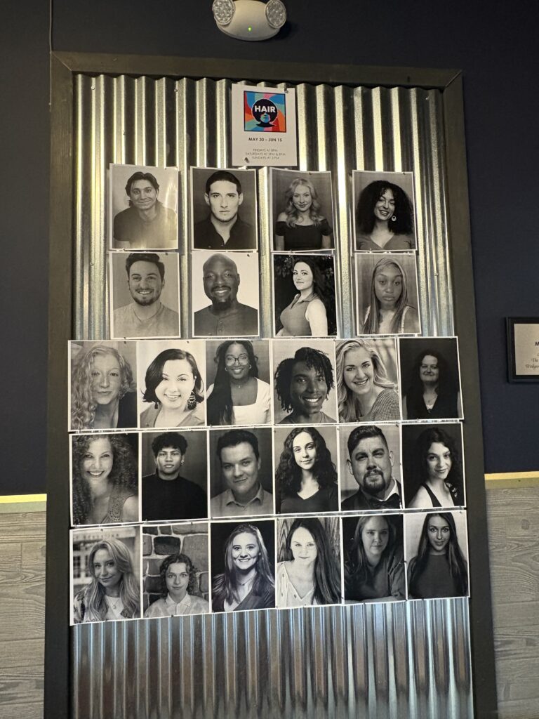 A display outside the theater of the cast's portraits.