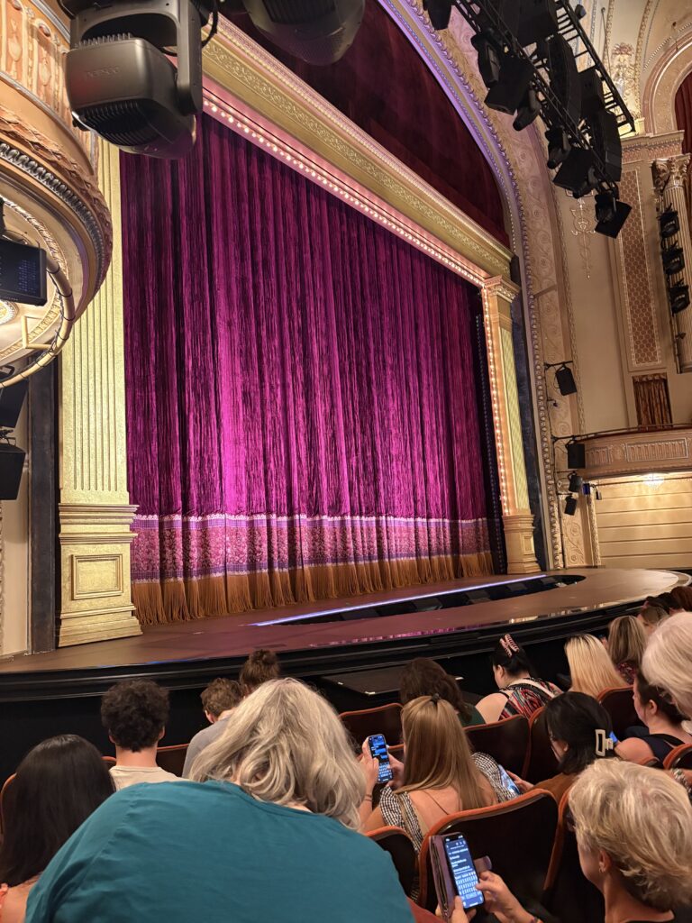 The stage of Gypsy. The purple of the curtain and gold pillars of the Majestic Theatre give a decadent over the top feeling. 