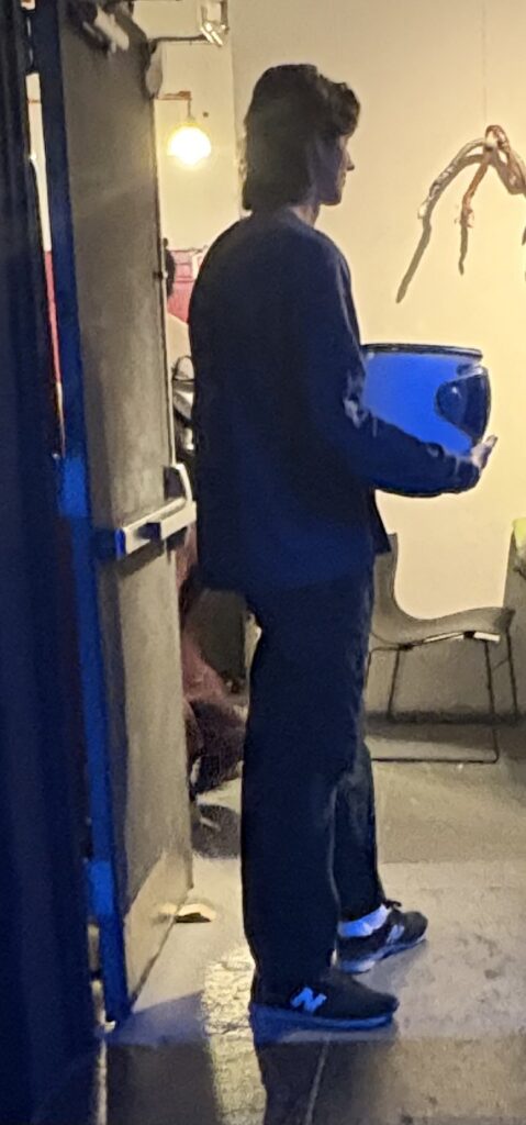 Usher collecting tickets in an astronaut's helmet.